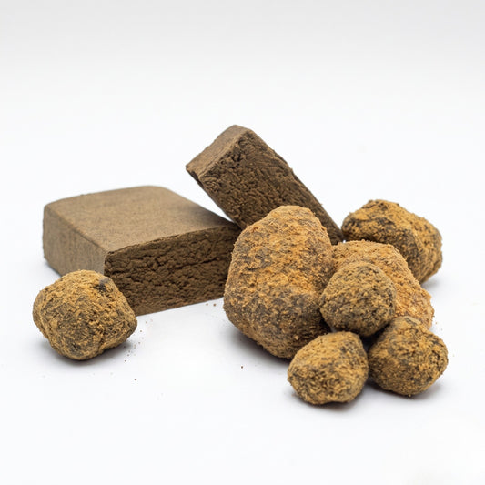 Pack Consumidor Experiente Cannalabis com peças de Moon Rock 80% CBD cobertas de pólen e blocos de resina Gold Press 18% CBD em fundo branco.